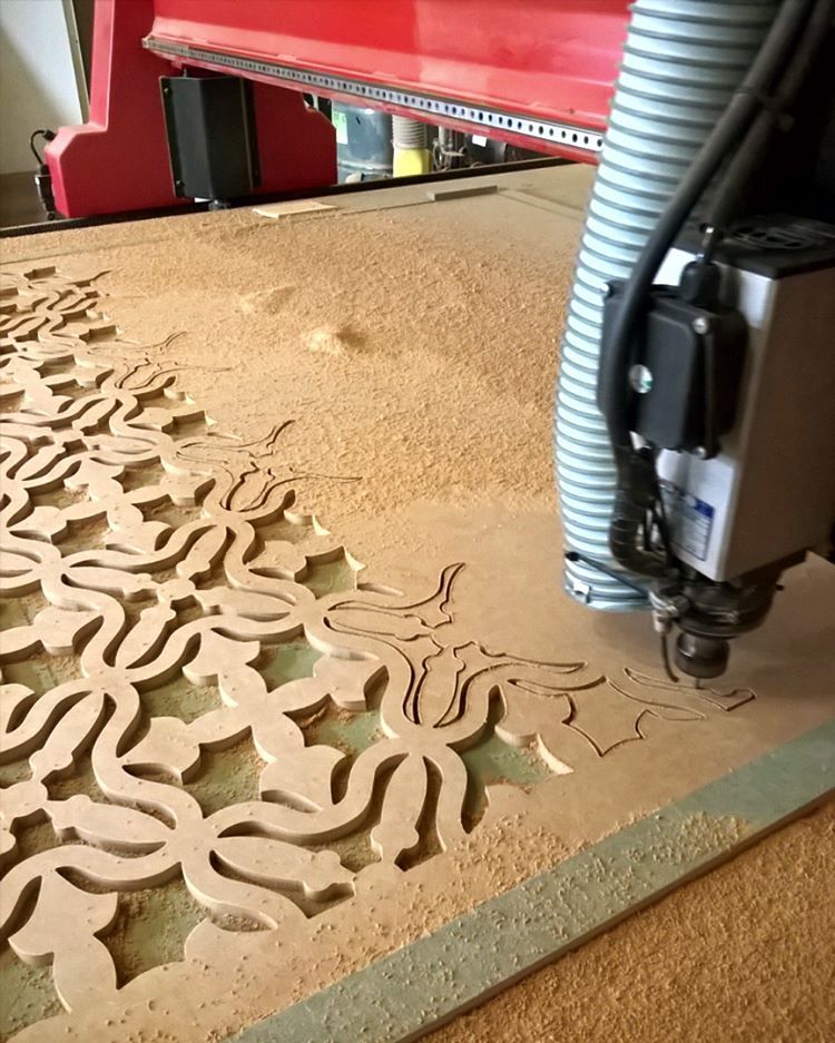 Machine CNC usinant un panneau décoratif ajouré