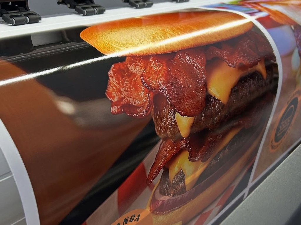 Bâche publicitaire en cours d'impression sur un traceur grand format